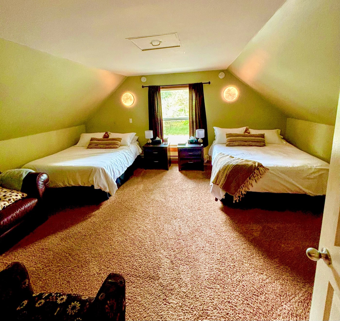 A bedroom with two queen beds under the sloped ceiling